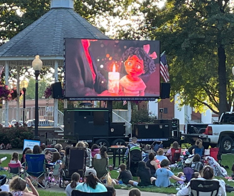 families watching outdoor movie in town center in Norton, OH. - Game Craze Party & Event Rentals